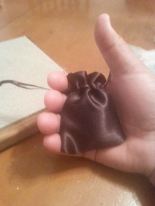 Image is a small leatherette coin pouch held in a man's hand